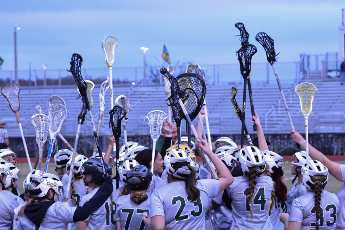 Reach+for+the+stars.+All+of+the+girls+lacrosse+players+lift+their+stick+towards+the+sky+as+their+routine+before+every+game+to+break+off+the+huddle.+After+they+dispersed%2C+the+starting+players+went+onto+the+field+and+played+against+Berkely+Preparatory+School.