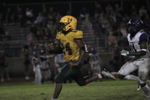 Senior Malachi Ford rumbles through the soggy turf at the Coyote field during the homecoming game match up against the Knights from River Ridge. Fords long run set up a Coyote touchdown. 