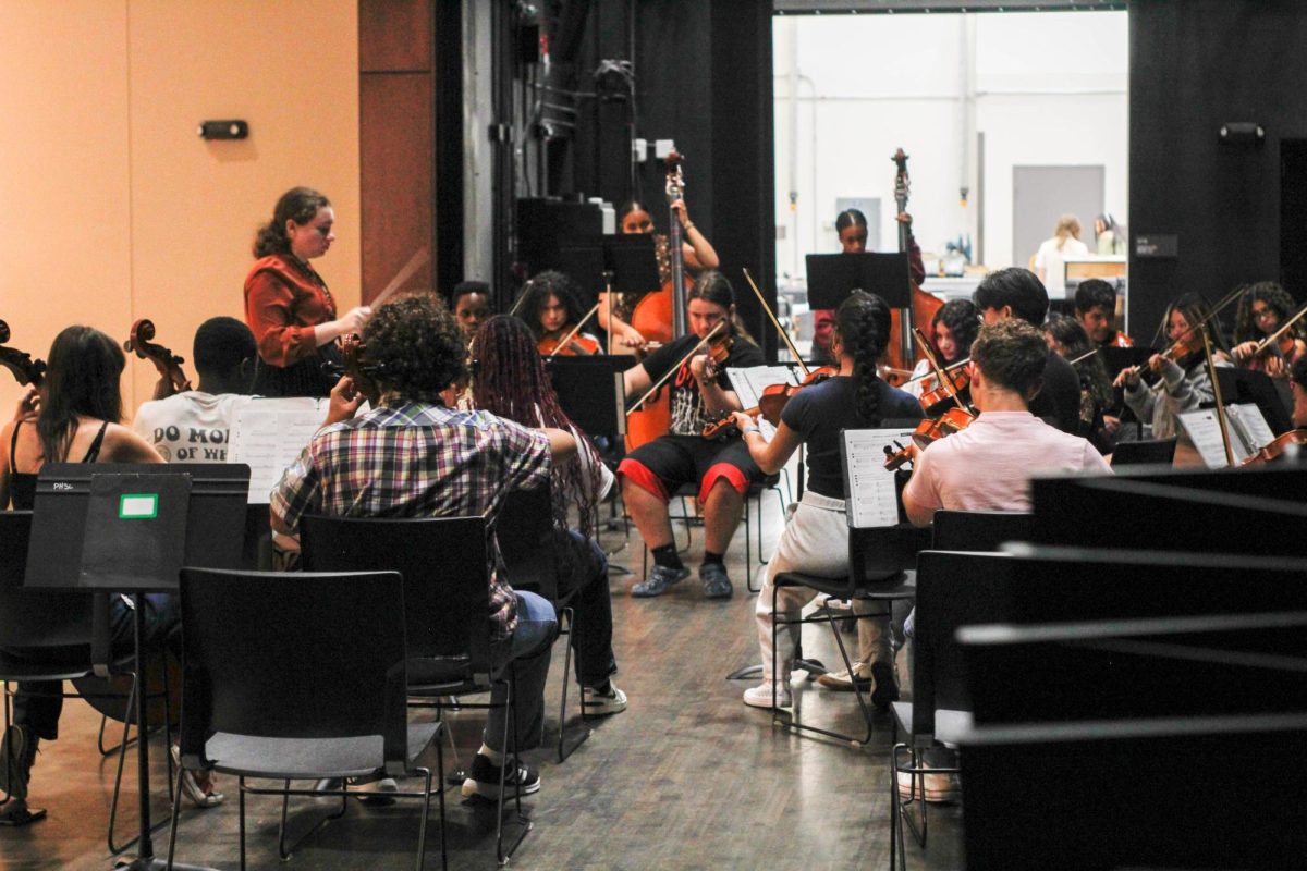 Practice, practice, practice! John McNamara practices amongst his orchestra peers at the Institutional Performing Arts Center, showing off his violin talents. Performers were given a school related absence on September 30th, 2024, to go to the IPAC during the start of their 2nd period until the start of their 5th period, perfecting their act as guests would be paying to see it. “Learning both guitar and violin is pretty difficult. The notes are different and the strings don’t work the same,” said senior violinist Angelina Ramirez. 