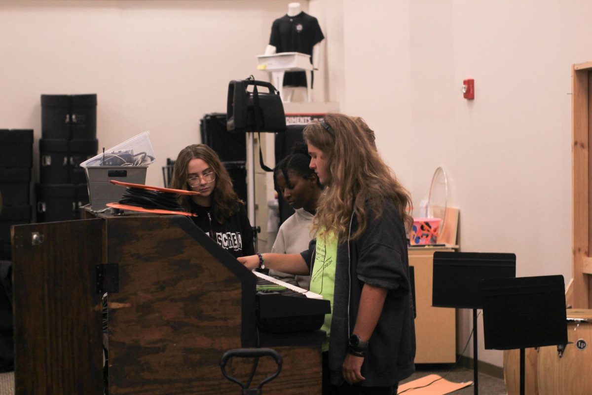 Keys. Junior Gavin Hinton works together on the keyboard with sophomore Alexis Sassman.